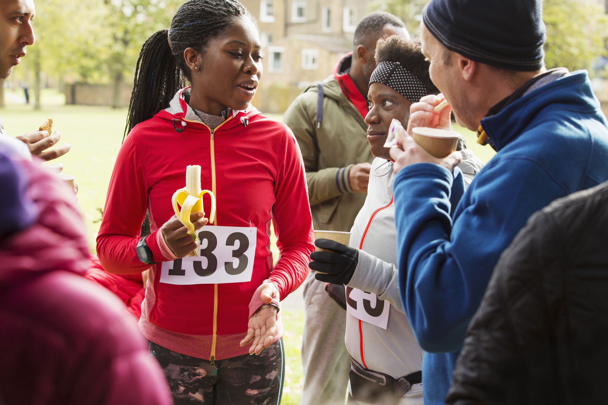 runners drinking water and eating banana at charity royalty free image 948658892 1550697717